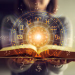 Woman holding a astrology book. Astrological wheel projection, choose a zodiac sign. Astrology esoteric concept.